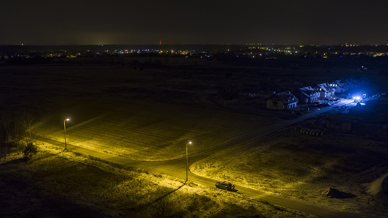 Beleuchteter Baubereich einer Neubausiedlung bei Nacht aus der Vogelperspektive