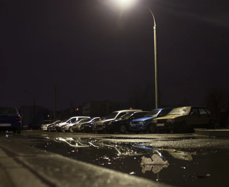 Unbewachter Parkplatz bei Nacht im Laternenlicht